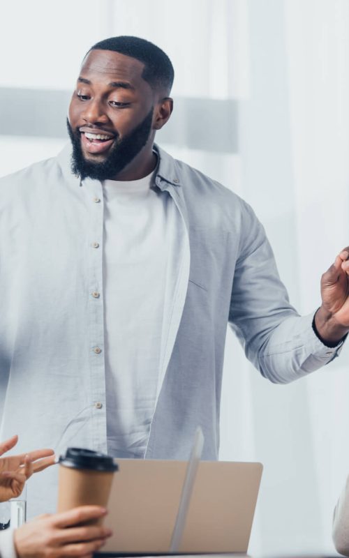 african american man talking with colleagues during meeting in creative agency